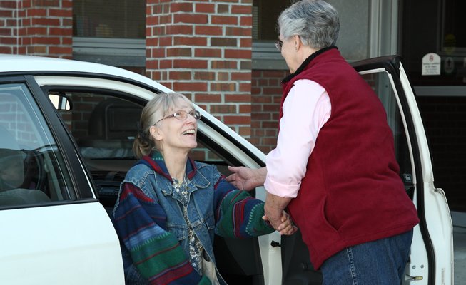 Volunteer helping someone out of a car