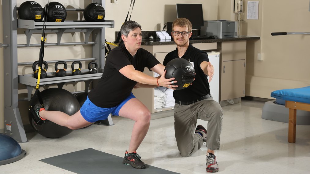 Male physical therapist works with a female patient