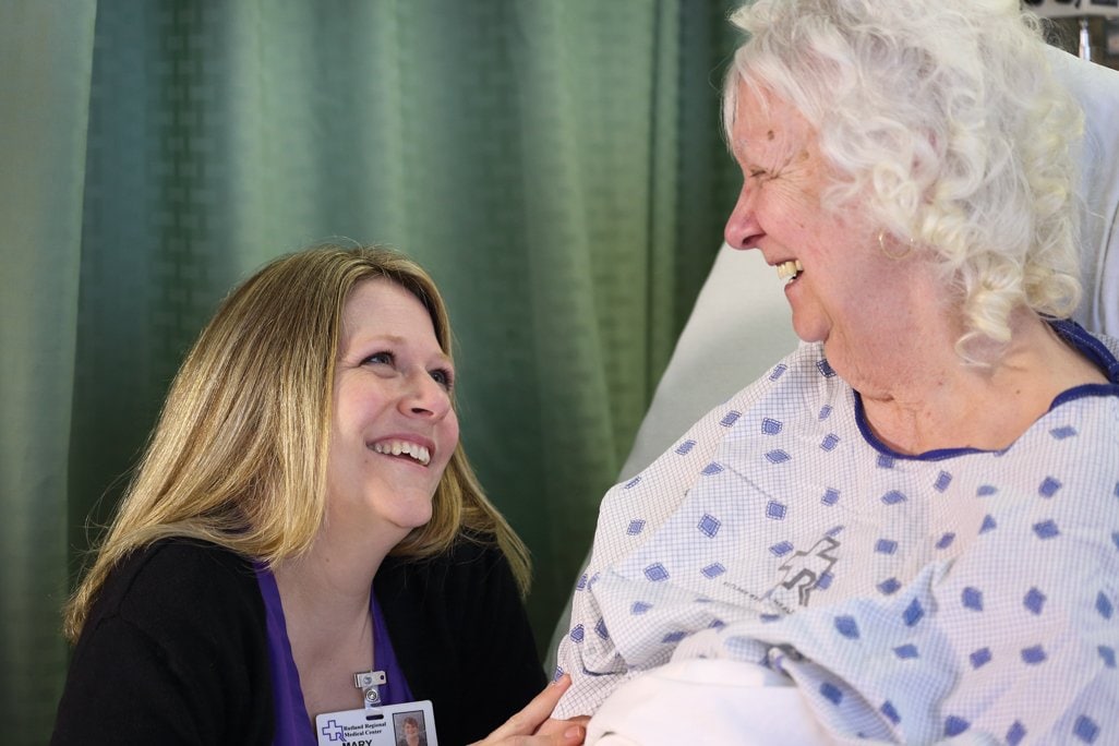 Nurse talking to a patient in a bed