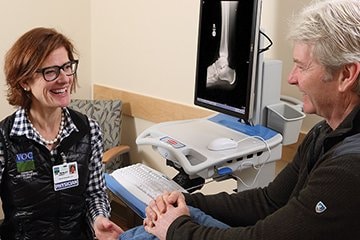 Orthopedic surgeon Deborah Henley, MD, exams a male patient